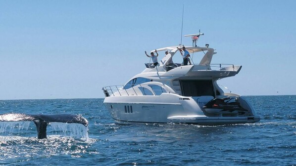 A large yacht with multiple decks and a helipad, sailing on a calm sea.