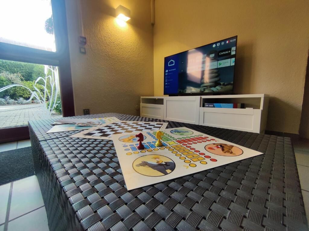 A checkered table with a board game, a television on the wall, and a door leading outside.