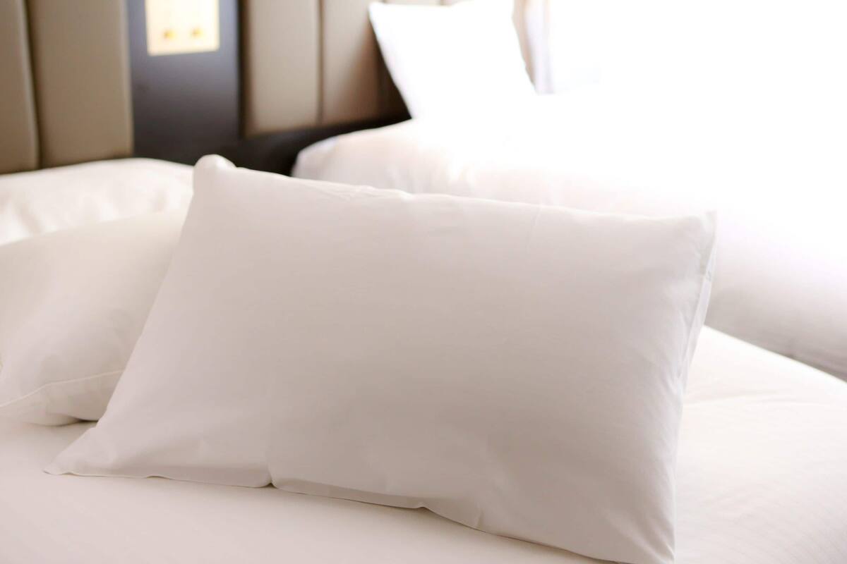 A bed with white bedding and a headboard.