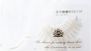 Une casquette blanche ornée d’un emblème et d’une inscription dorés.