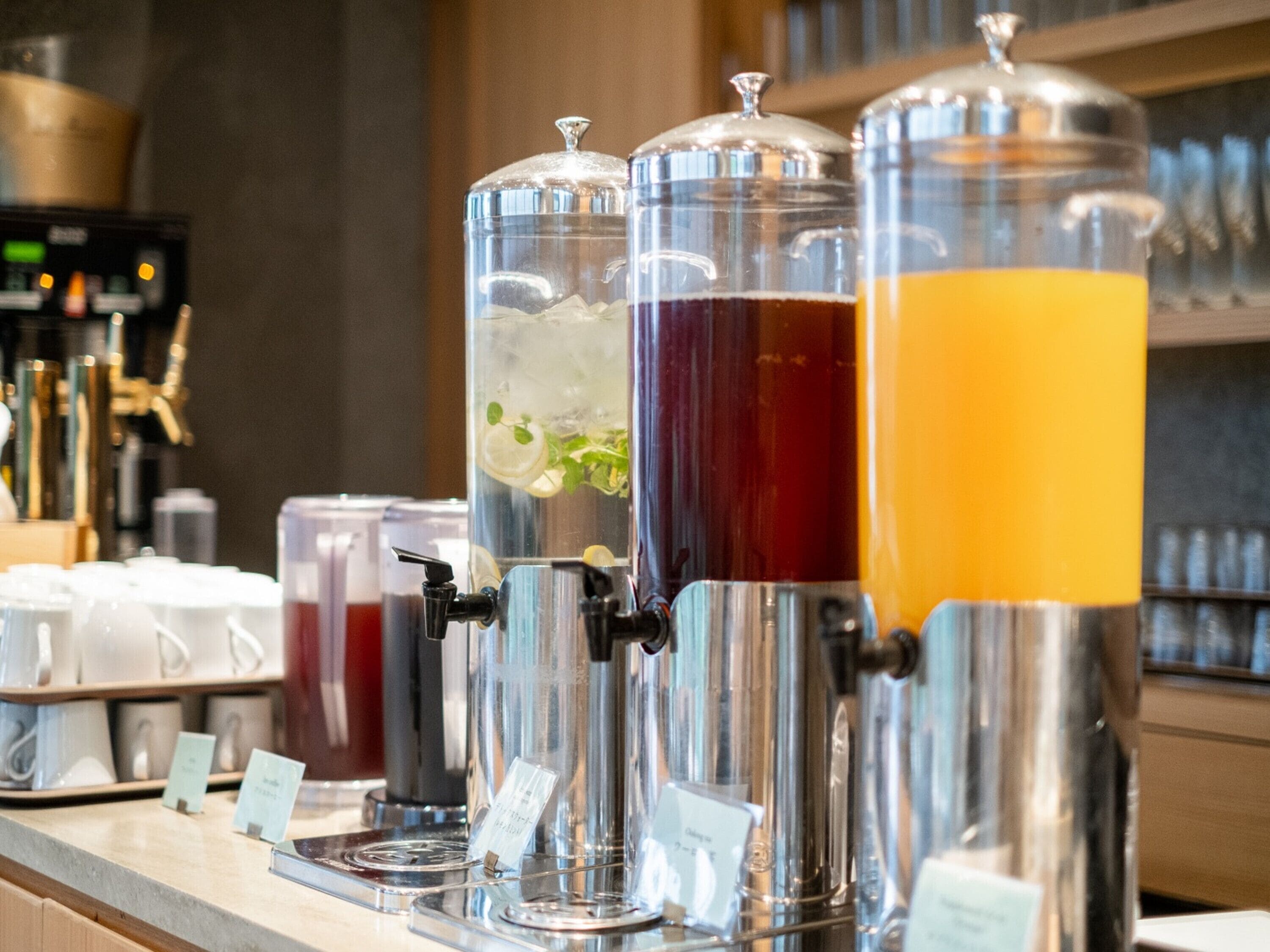 Un distributeur de boissons doté de plusieurs récipients, chacun contenant une boisson d’une couleur différente.