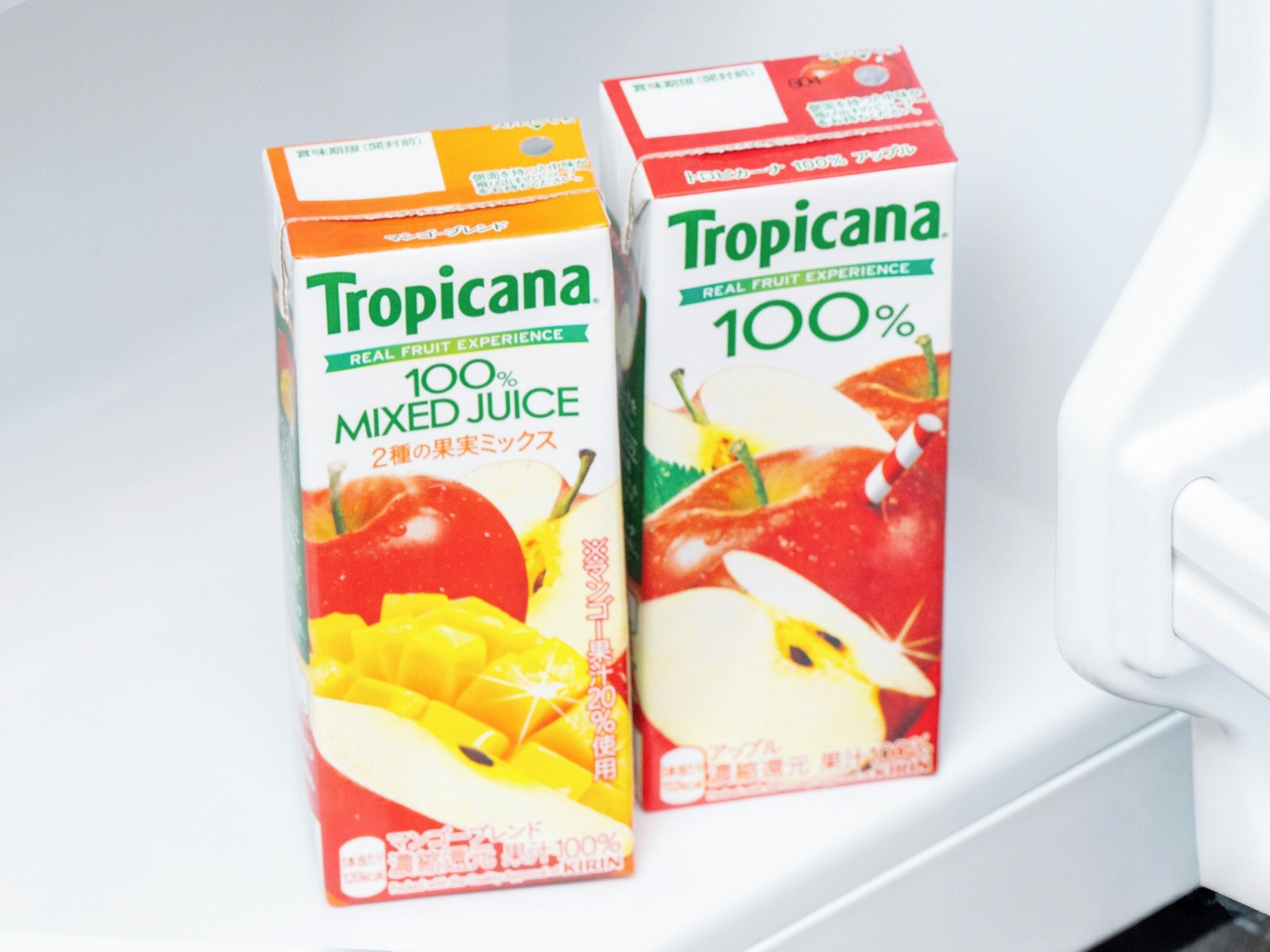 Deux emballages de jus Tropicana sur une surface blanche.