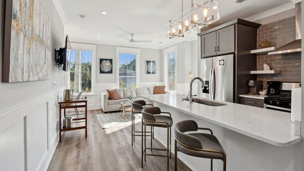 A modern kitchen with a central island, stainless steel appliances, and a large window providing natural light.