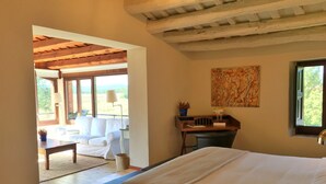 A bedroom with a large bed, a desk, a chair, and a window. - Hotel Masia la Palma (Cabanelles)