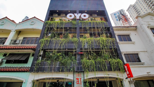 Um hotel com o nome 'OYO' em destaque na fachada.