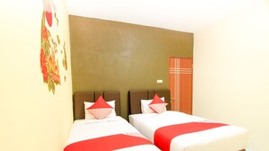 Quarto de hotel com duas camas, cada uma com roupa de cama vermelha e branca, uma cabeceira marrom e uma porta vermelha.