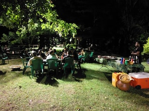 An outdoor dining area with tables and chairs, surrounded by greenery. - Big Foot Safari Lodge (Wli)