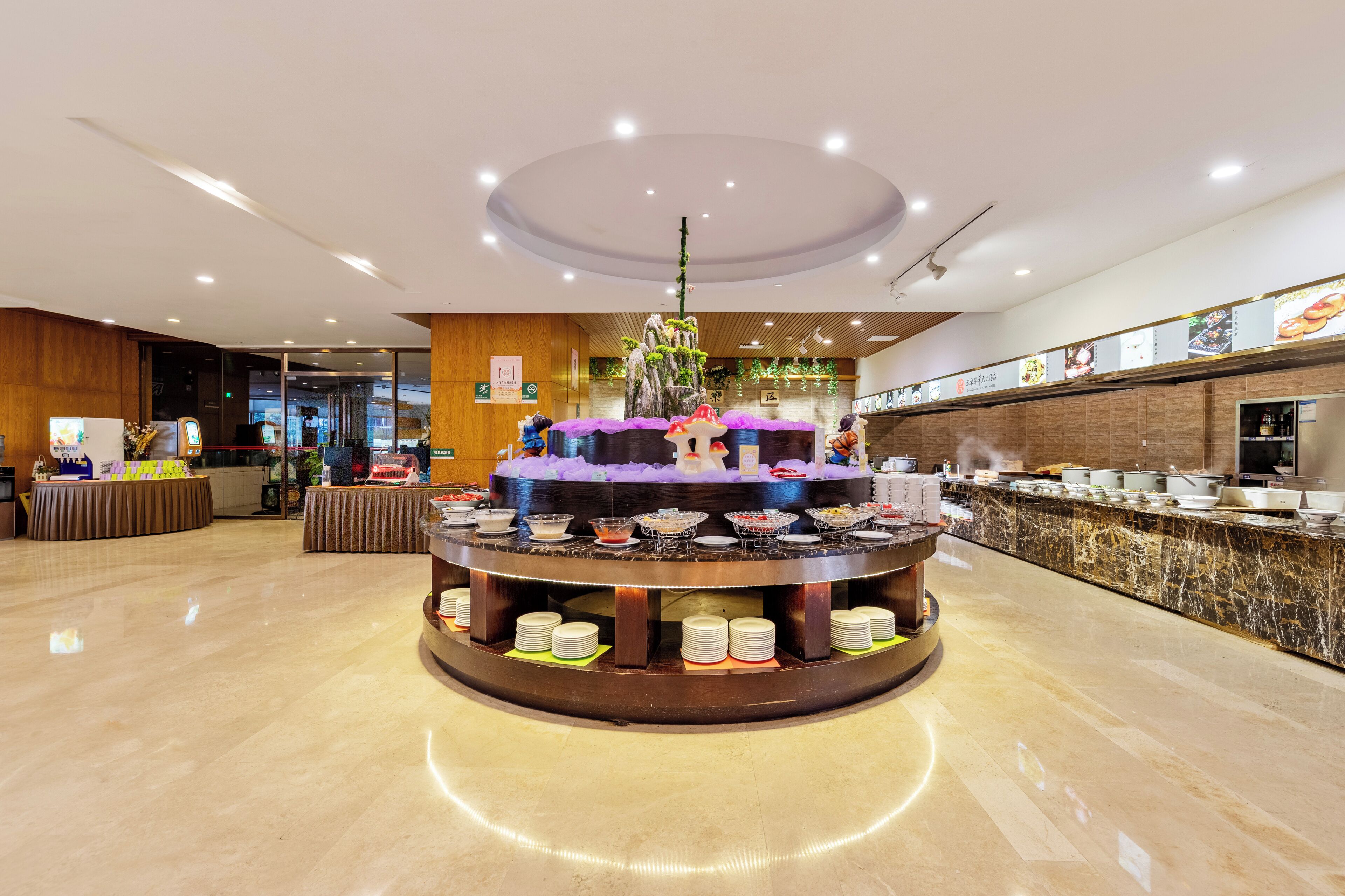 A buffet area with a central island, a reception desk, and a counter with food displays.