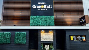Entrada de um hotel com uma placa indicando 'HOTEL Grand Bali RESORT'.
