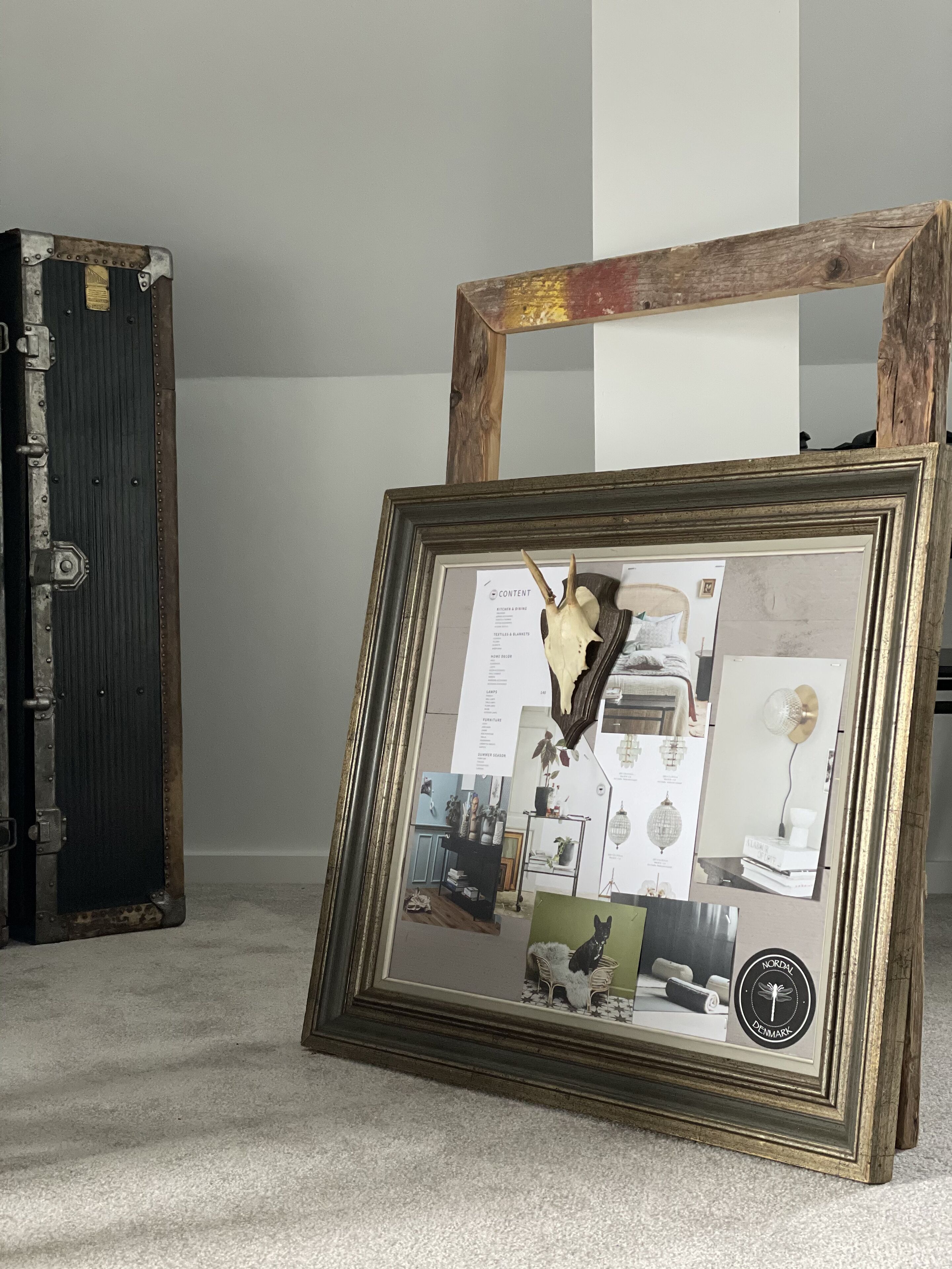 A framed collage of various interior design elements, including a dog, a lamp, and a bookshelf, displayed on a carpeted floor.