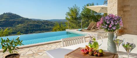 Una piscina al aire libre, sombrillas, tumbonas