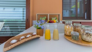 Una presentación de desayuno con pasteles, fruta y bebidas para el desayuno sobre una bandeja.