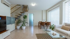 Una sala moderna con una escalera, un comedor y un sofá.