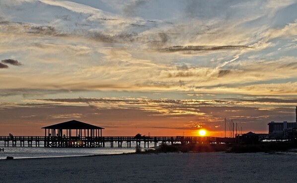 A beach with a pier and a gazebo.