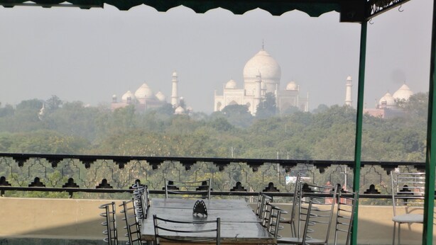 Un área de comedor al aire libre con vistas al Taj Mahal.