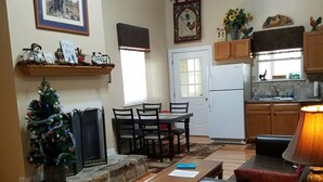 A spacious living room with a fireplace, a dining area, and a kitchen.