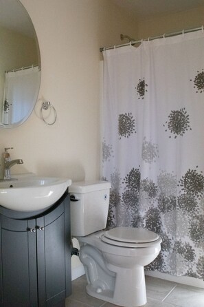 A bathroom with a sink, toilet, and shower curtain.