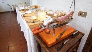 Een buffet met verschillende kazen, vleessoorten en broden.