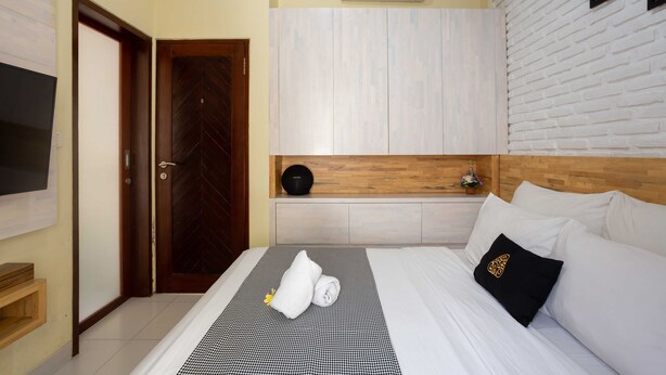 Ein Hotelzimmer mit Bett, Fernseher, Kleiderschrank und Klimaanlage.