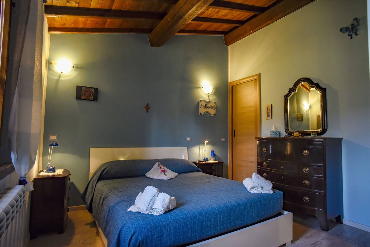 A bedroom with a bed, dresser, nightstands, and a mirror.