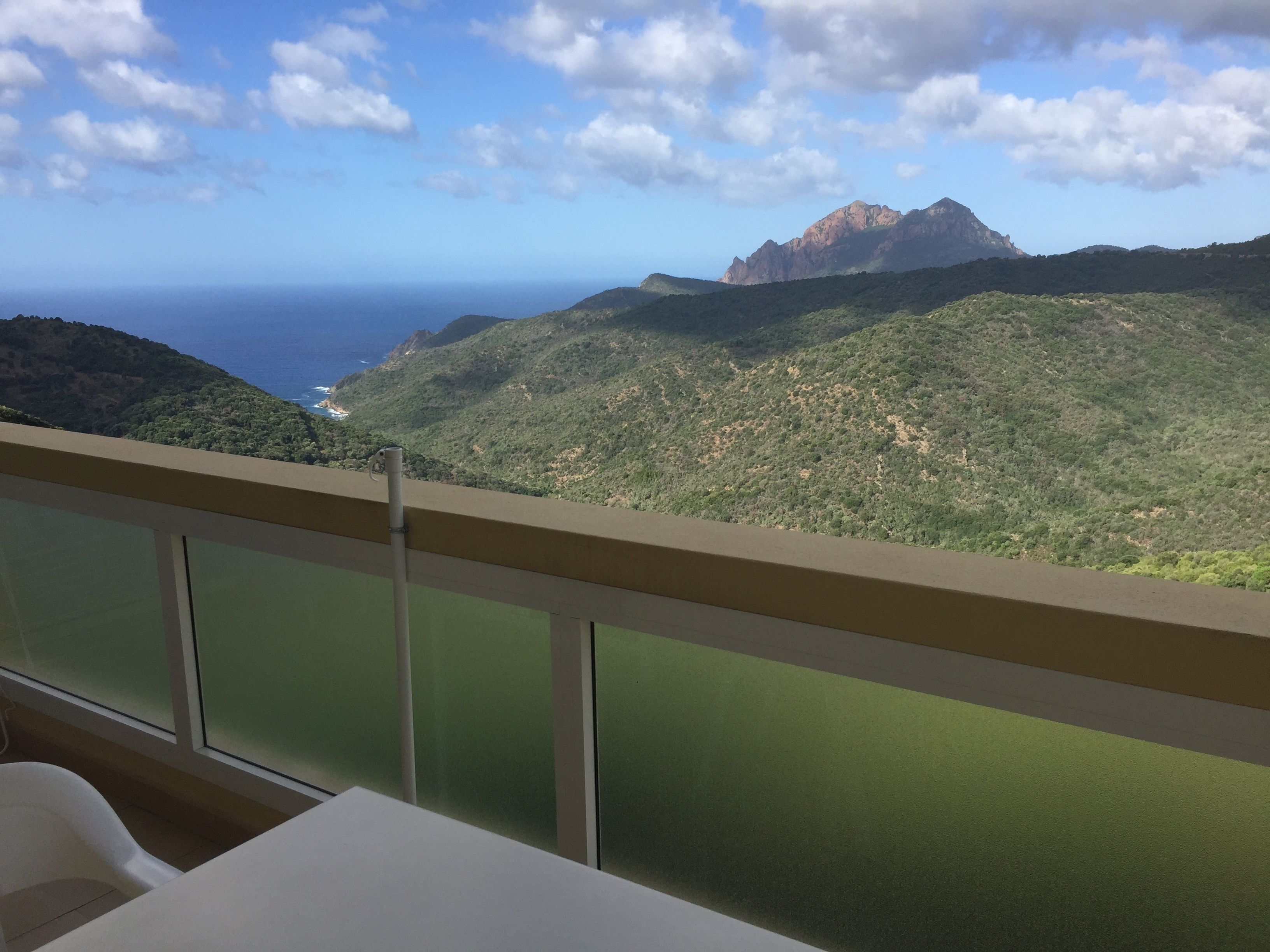 Un balcón con vistas a un paisaje montañoso y al océano.