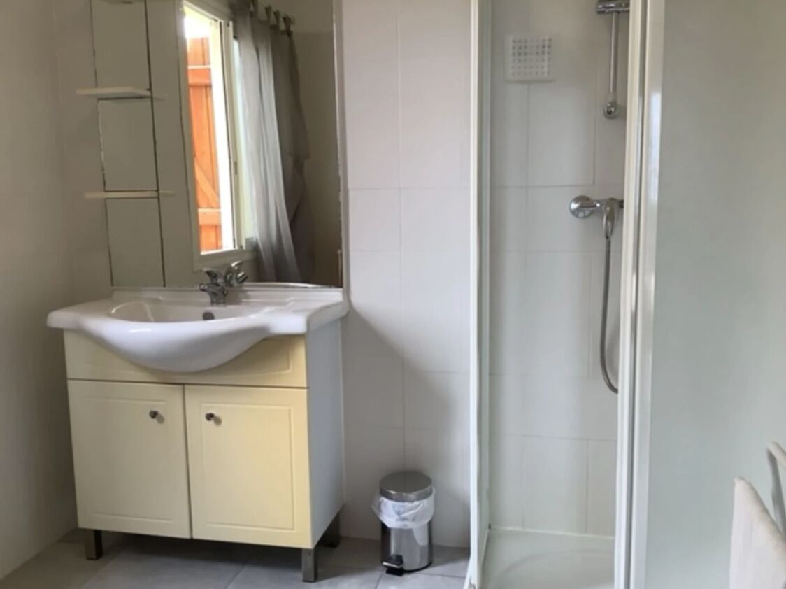 Un baño con lavamanos, espejo y ducha.