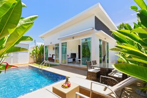 A modern house with a swimming pool, outdoor furniture, and tropical plants. - Tropical Stay at 2BR Pool Villa Greens 8 (Rawai)