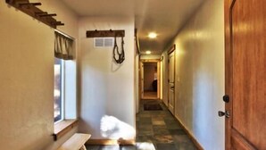 A hallway with a wooden bench, a coat rack, and a door. - Beautiful 6 Bedroom, 4 Bathroom Home Centrally Located and Perfectly Appointed (South Lake Tahoe)