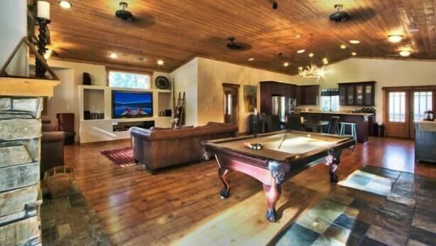 A spacious living area with a pool table, a fireplace, and a kitchen area. - Beautiful 6 Bedroom, 4 Bathroom Home Centrally Located and Perfectly Appointed (South Lake Tahoe)