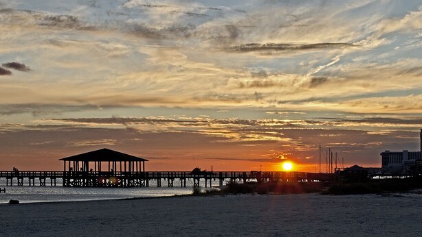 A beach with a pier and a gazebo.