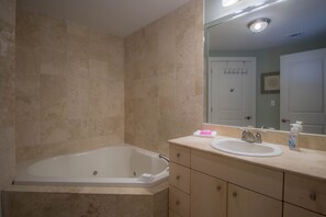 A bathroom with a bathtub, a sink, and a vanity with drawers. - I'll Have A Side Of Beach With My Morning Coffee! Directly On The Sand!!! (Biloxi)