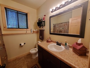 A bathroom with a vanity, sink, mirror, and toilet. - Northwoods Wisconsin Retreat!!  Newly built cabin sleeps 12 comfortably.   (Trego)