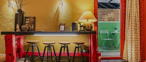A bar area with stools, a table, a lamp, and a fire extinguisher.