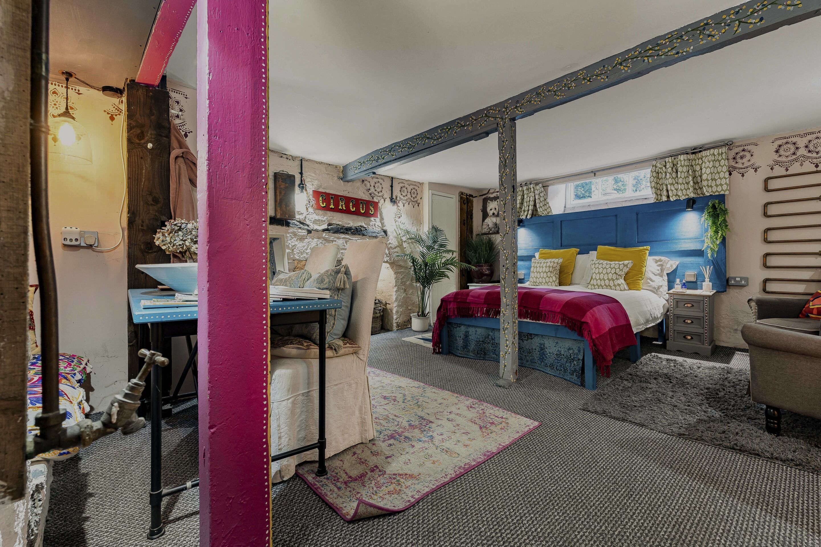 A bedroom with a bed, a desk, and a chair.