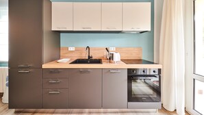 A modern kitchen with a wooden countertop, stainless steel appliances, and a built-in oven. - Villa Marija (Pula)