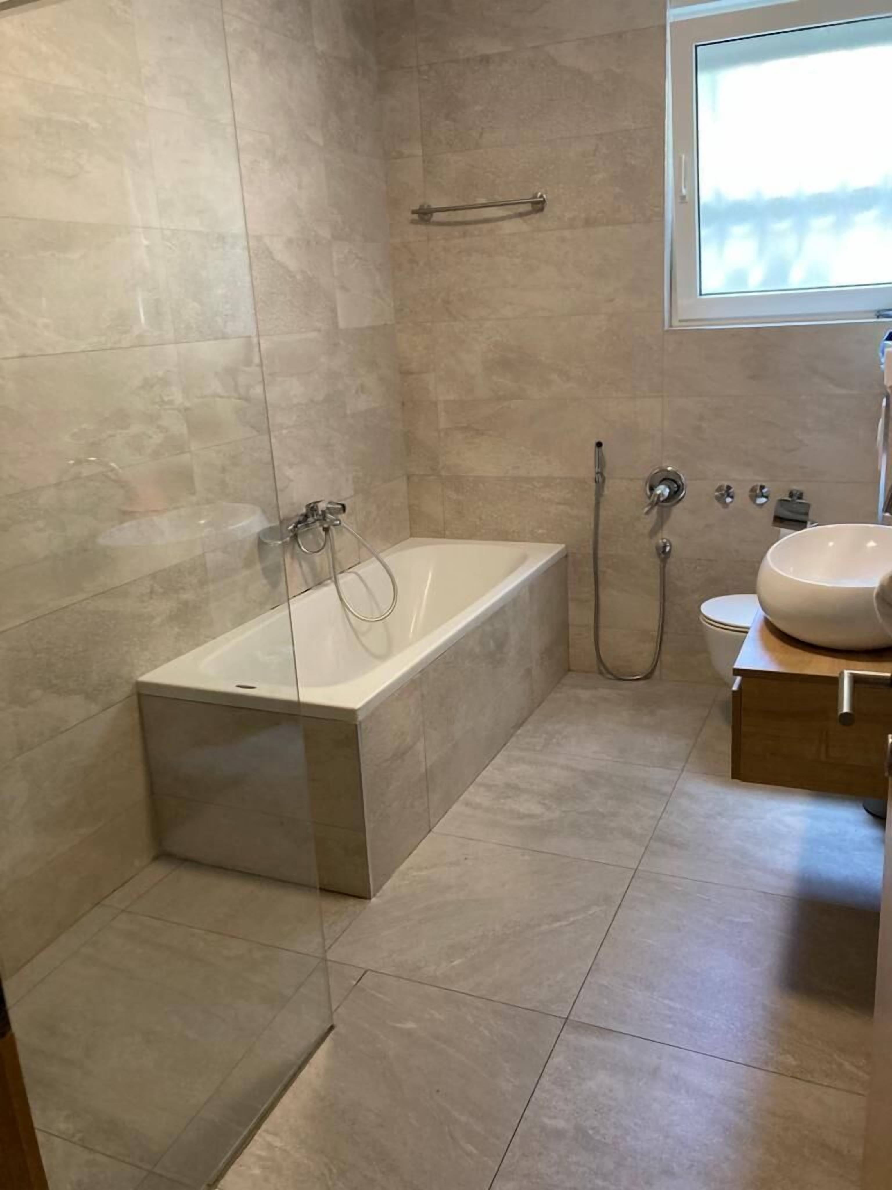 Ein modernes Badezimmer mit einer freistehenden Badewanne, Toilette und Waschbecken.
