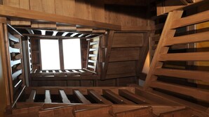 Un intérieur en bois avec une fenêtre, un plafond à lattes et des poutres en bois.