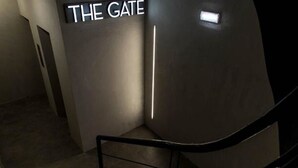 Una escala amb un senyal que diu “THE GATE” en un passadís poc il·luminat.