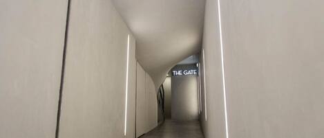A modern, minimalist hallway with a sign reading "THE GATE" at the end.
