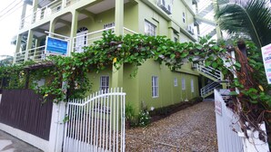 Un immeuble à plusieurs étages doté de balcons, d’une entrée sécurisée et d’une enseigne indiquant qu’il s’agit d’une maison d’hôtes.
