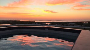 Une piscine avec vue sur le coucher de soleil.