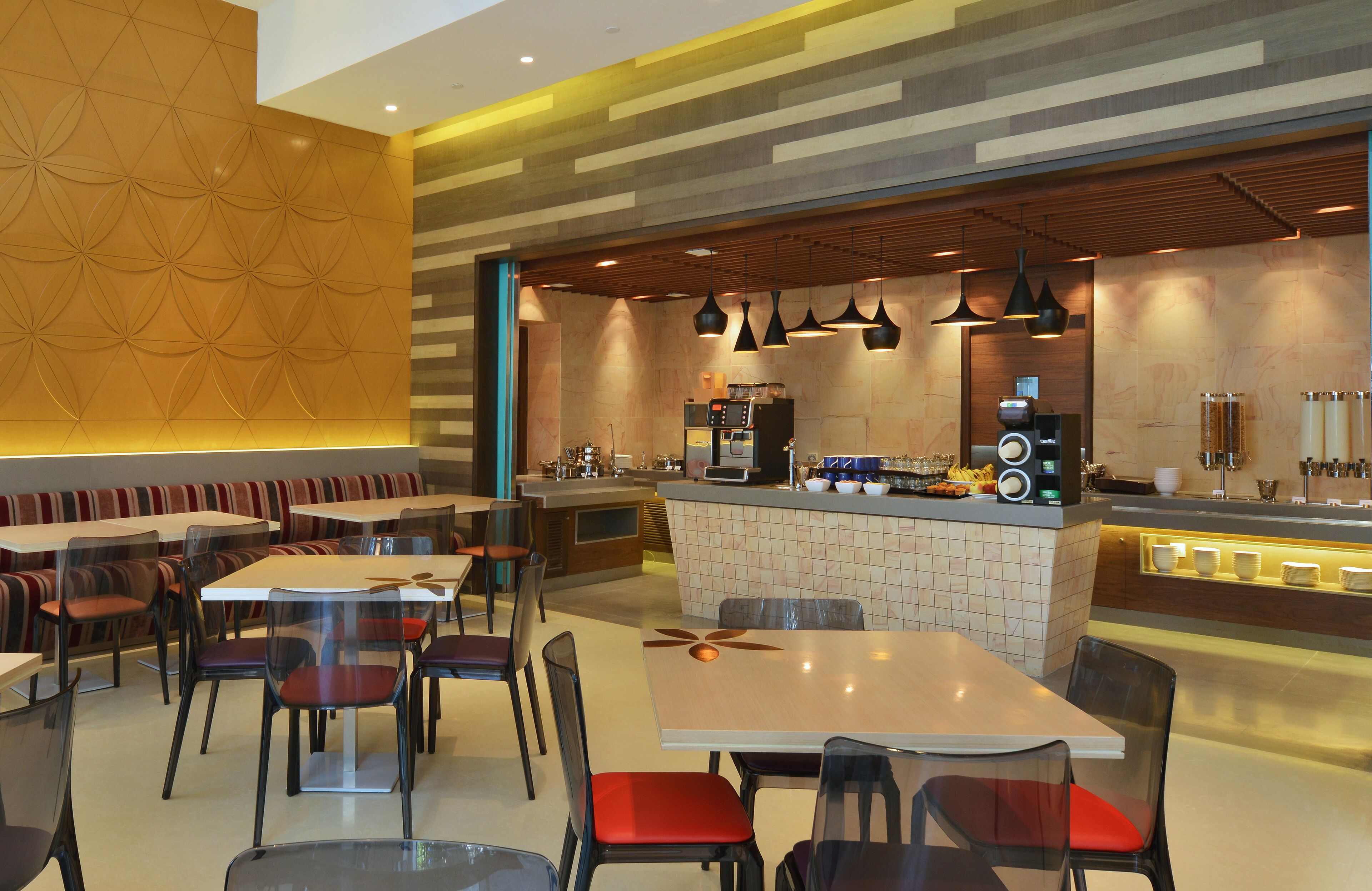 A modern restaurant with a bar area, booths, and tables.