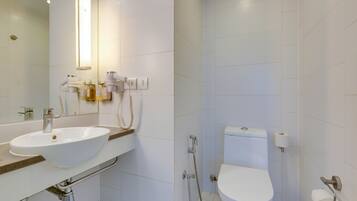 A modern bathroom with a white sink, toilet, and shower.