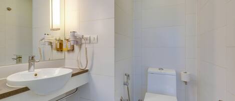 A modern bathroom with a white sink, toilet, and shower.