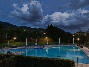 A swimming pool with lounge chairs and umbrellas, surrounded by greenery and hills. - Aurelia Rta Detta Il Cascinale (Montignoso)