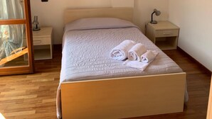 A neatly arranged bedroom with a bed, a nightstand, a lamp, and a painting on the wall. - Aurelia Rta Detta Il Cascinale (Montignoso)