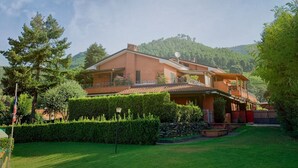A large, two-story house with a flat roof and a balcony, surrounded by well-maintained lawns and trees. - Aurelia Rta Detta Il Cascinale (Montignoso)