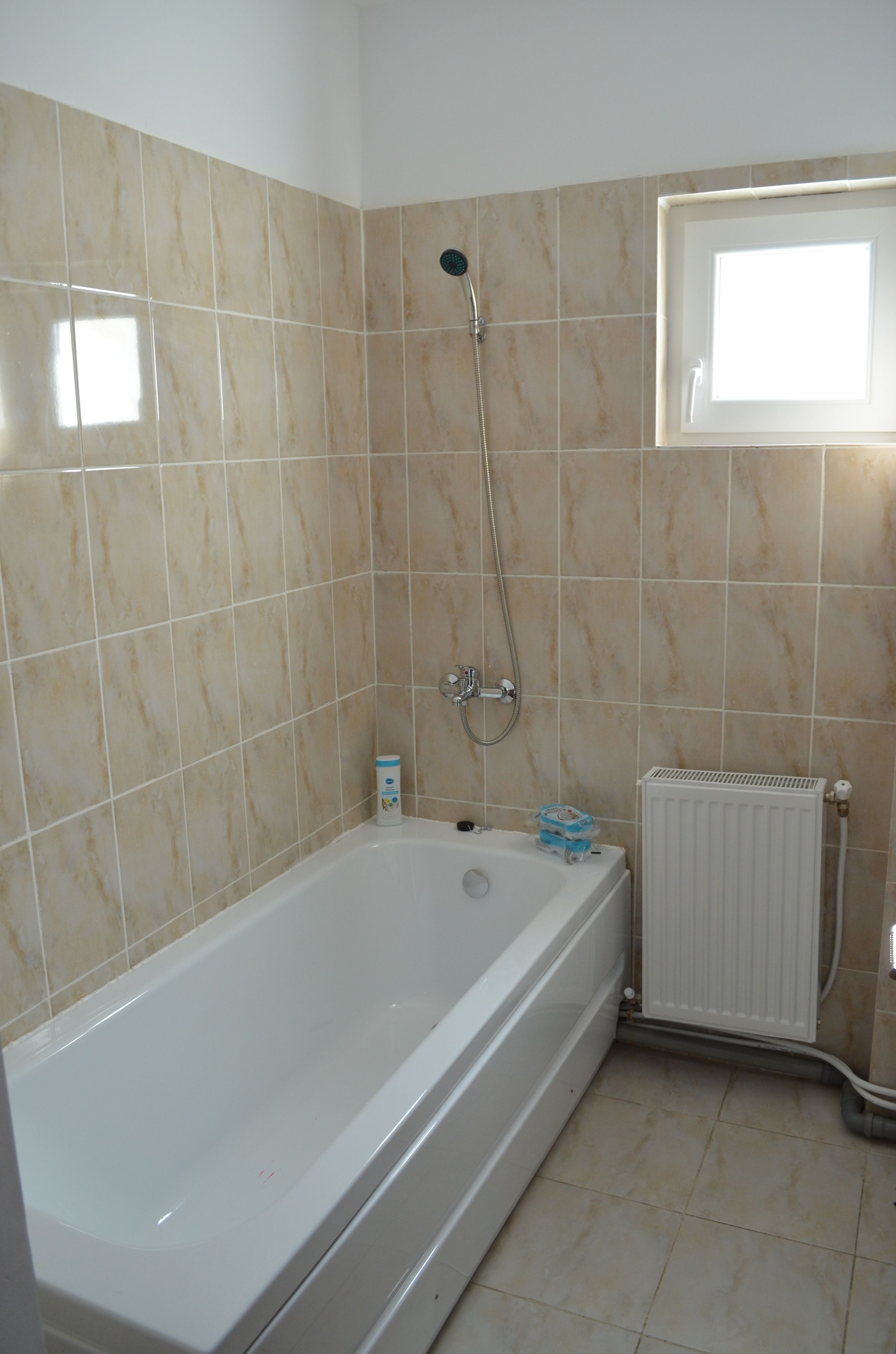 A bathroom with a bathtub, a shower, and a window.