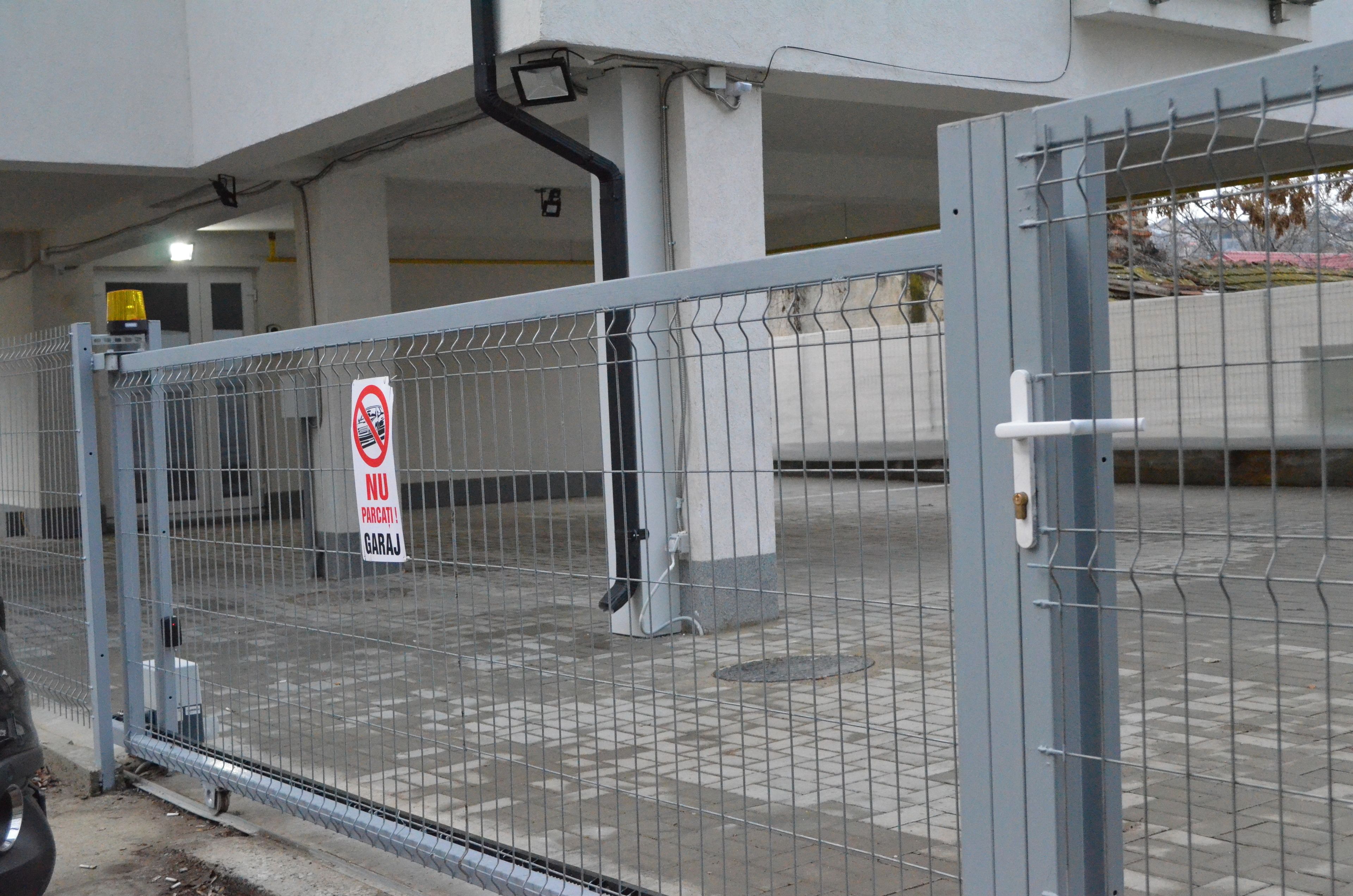A gated parking area with a no-parking sign.