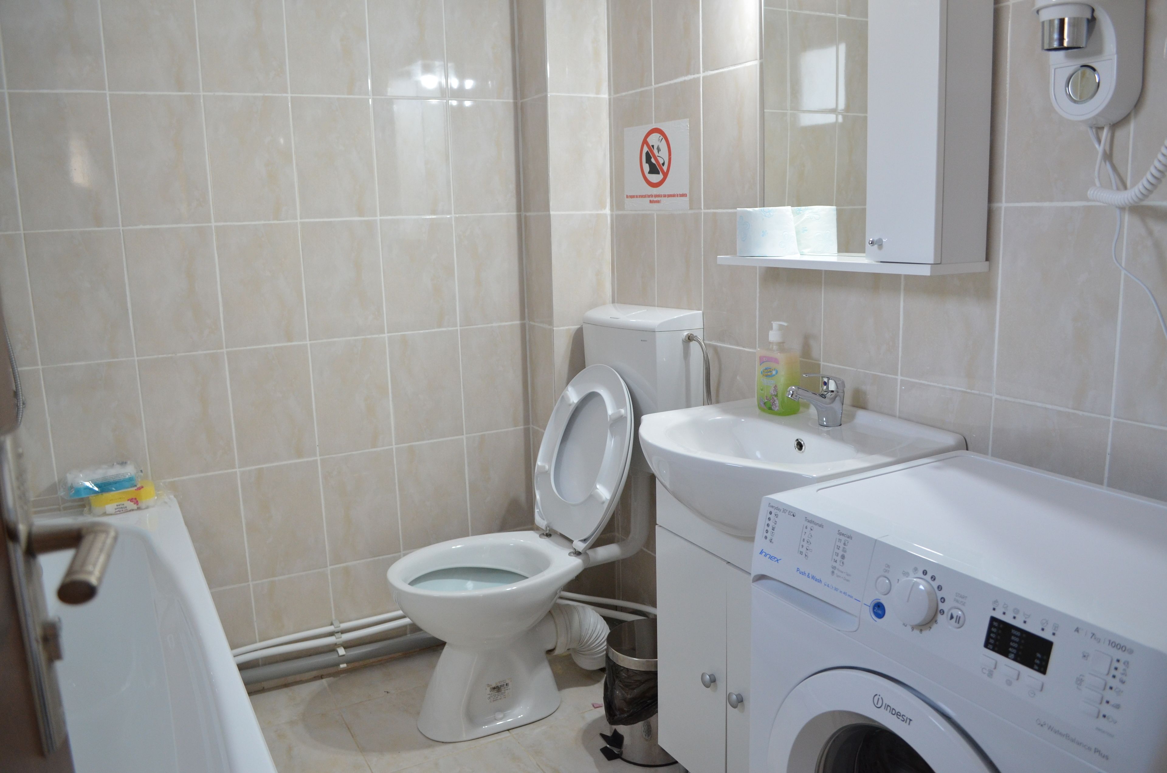 Une salle de bain équipée de toilettes, d’un lavabo et d’un lave-linge.